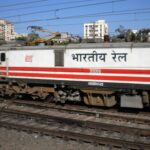 Indian Railways electric locomotive at a station, showcasing the country's extensive railway network.